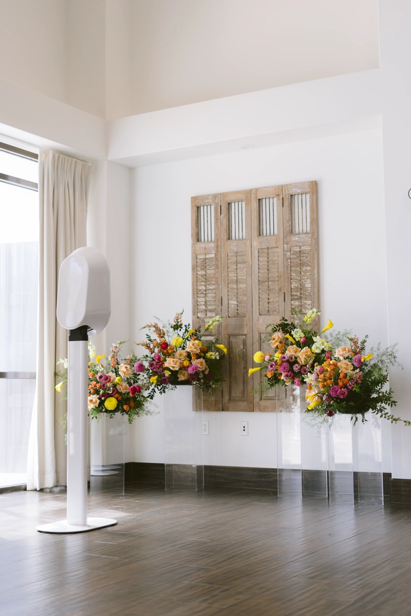 Sleek modern digital photo booth styled with fresh florals at a wedding